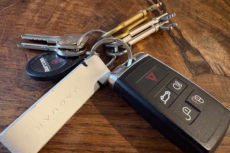 A bunch of keys including a modern remote car key fob