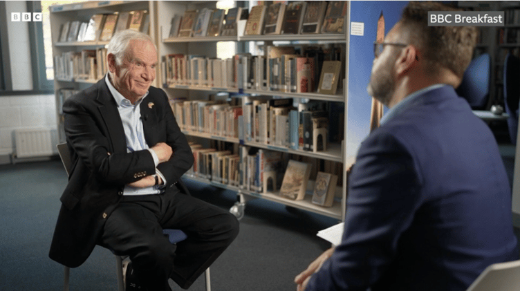 Lord Jeffery Archer in the library of Wellington School being interviewed by the BBC's Jon Kay.